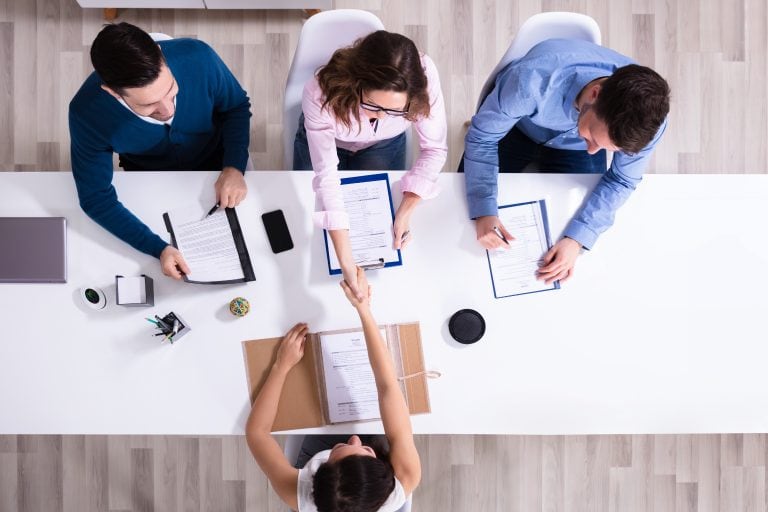 Group of office workers around a desk viewed from above